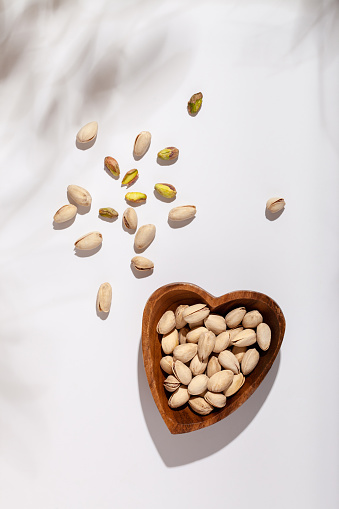 Pistachios in a wooden heart-shaped bowl