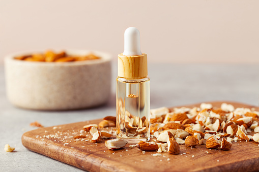 Close-up of Almond essential oil jar and chopped nuts