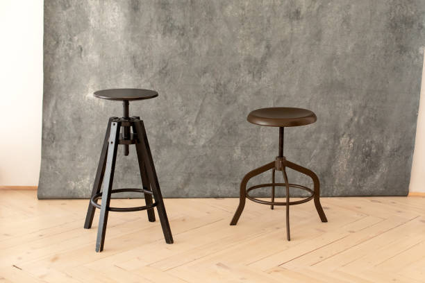 istock black minimalist metal chairs against grey background. Concept modern interior and design furniture in room. High stool in loft style. Retro Bar chair. Vintage wooden metal chair. Tall standing table. 1403468946