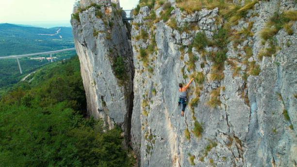 istock COPY SPACE: Drone view of a female rock climber ascending up a challenging cliff 1403469991