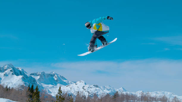 istock Snowboarding pro doing a rotating grab stunt while riding in Vogel. 1403472098