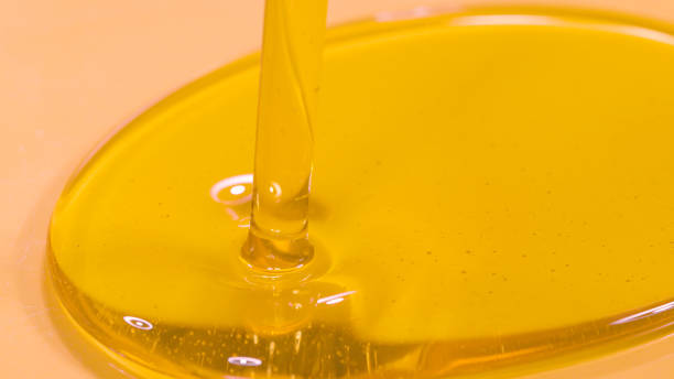 istock MACRO: Unrefined cold pressed walnut oil getting poured into a large container. 1403472220