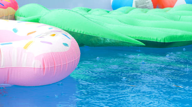 istock CLOSE UP: Raindrops fall down on the colorful toys floating around empty pool. 1403472947