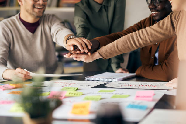 istock Close up of creative business team gathering hands in unity while working in the office. 1403474479
