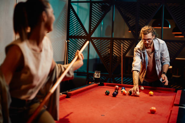istock Happy man and his girlfriend enjoying while playing snooker in a pub. 1403475214