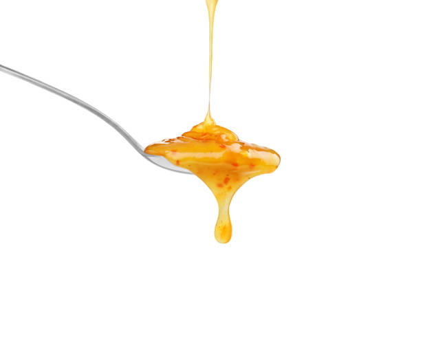 istock bright yellow sauce in a spoon on a white background 1403477954