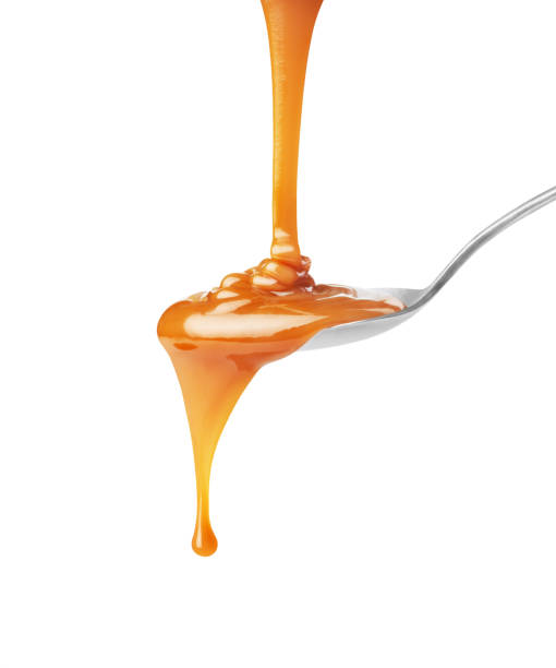 kroplówka karmelu w łyżce na białym tle - caramel sauces sweet sauce pouring zdjęcia i obrazy z banku zdjęć