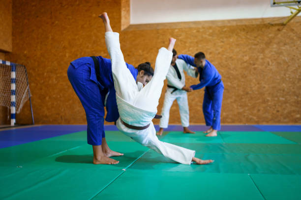 istock Two young couples of judo martial arts partners practicing new techniques in a gym 1403478306