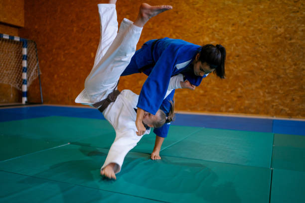 istock Two young female judo fighters showing technical skill while practicing martial arts in a fight club 1403478673