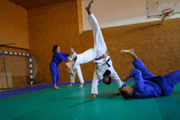 istock Two young couples of judo martial arts partners practicing new techniques in a gym 1403479023