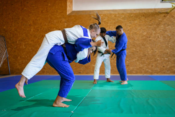 istock Two young couples of judo martial arts partners practicing new techniques in a gym 1403480149