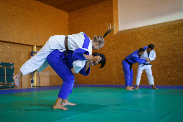 istock Two young couples of judo martial arts partners practicing new techniques in a gym 1403480664