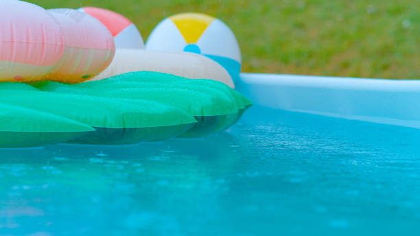 istock CLOSE UP: Backyard pool filled with floaties getting caught in autumn rainstorm. 1403482652