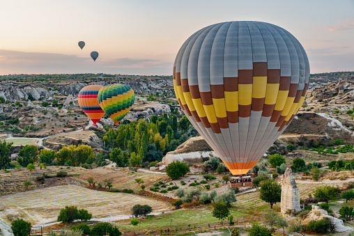 Awesome view of colorful hot air balloons flying over Goreme Historical National Park. Fabulous landscape of Cappadocia, Turkey.