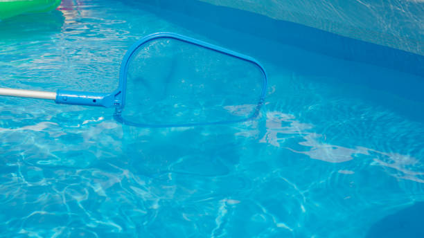 istock CLOSE UP: Unrecognizable pool cleaner uses a leaf net during maintenance works. 1403483656