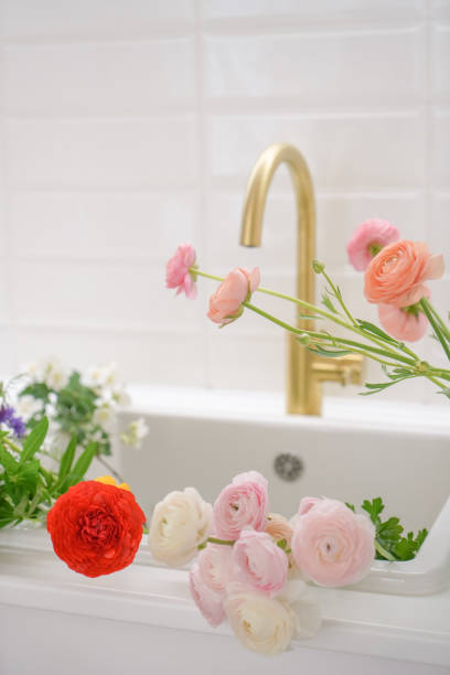 istock White kitchen with pink fresh ranunculus flowers 1403484703