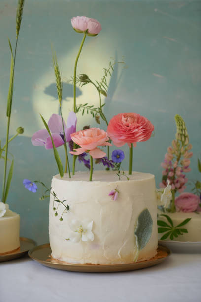 istock White cake with white cream with floral decor on a stylish background 1403484814