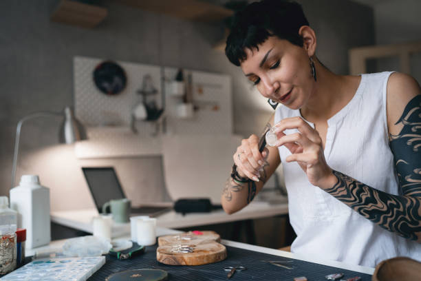 istock Caucasian craft woman using pliers while making epoxy jewelry at her workshop 1403486585