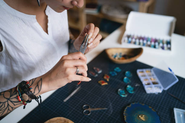 istock Caucasian craft woman using pliers while making epoxy jewelry at her workshop 1403486644