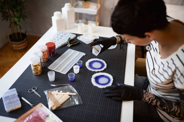 istock Craft woman pouring epoxy in the silicone mold, while working from her home workshop 1403488582