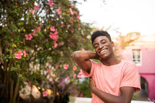Portrait of a young handsome African man. He is smiling and looking at the camera