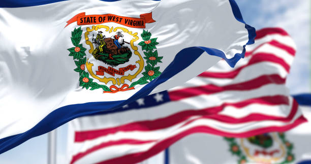 The West Virginia state flag waving along with the national flag of the US The West Virginia state flag waving along with the national flag of the United States of America. West Virginia is a state in the Southeastern region of the United States west virginia us state stock pictures, royalty-free photos & images