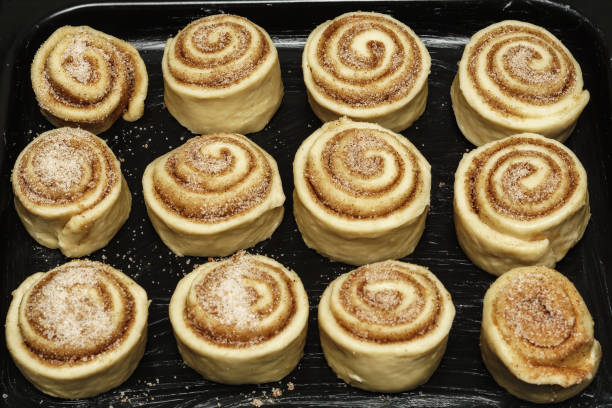 Baking Pan Full of Unbaked Cinnamon Roll Dough Ready to be Cooked. Uncooked dough background, pastry bakery process theme.