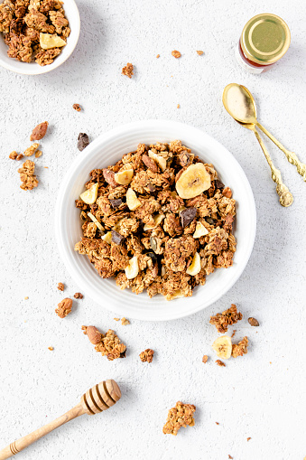 Healthy homemade granola on a white background top view with honey, stock photo. Breakfast cereal