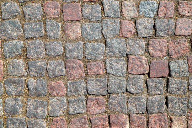 un vieux pavé pavé de blocs de granit rectangulaires comme arrière-plan - paving stone cobblestone road old photos et images de collection