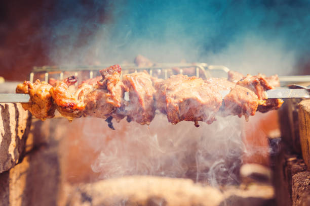istock Delicious juicy meat on skewers is fried on a fire 1403497382