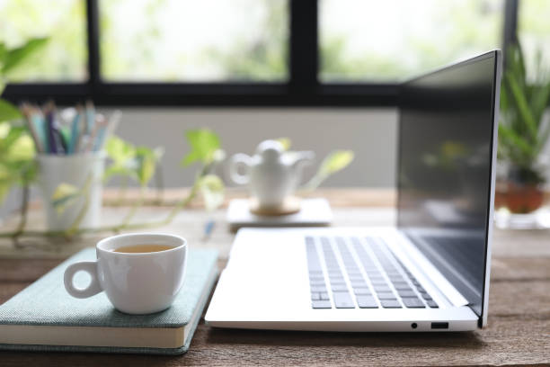 istock Tea cup and notebook side view and plant pot 1403500591