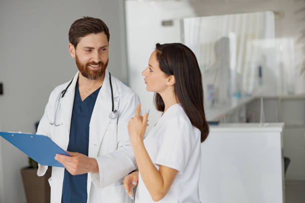 istock Doctor and nurse solve work issues standing near reception in clinic 1403502122