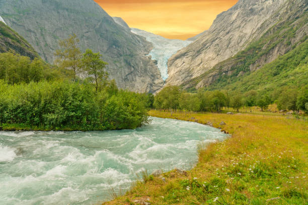 Sunset mountain landscape with glacier melting stream, Norway