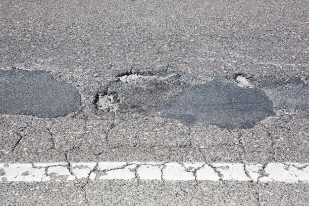 istock Cracked, broken and damaged asphalt road detail 1403505729
