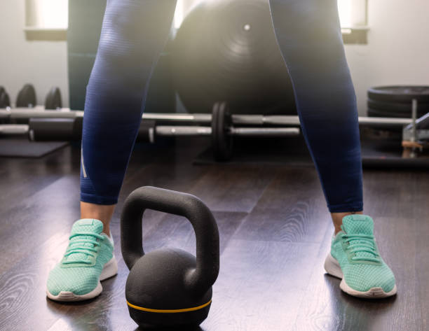 istock Woman's legs in the gym next to dumbbell, open legs 1403508402
