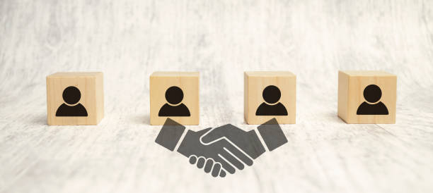 istock handshake icon screen on wooden cube block over employees wooden background 1403508498