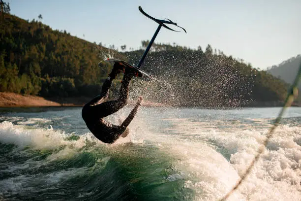 amazing view on man making extreme stunts jumping and flips on foil wakeboard over splashing wave