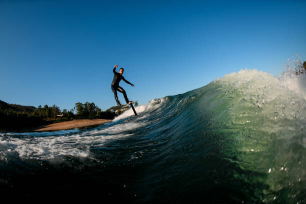 istock young athletic man in rides down the wave on a foil wakeboard 1403510475
