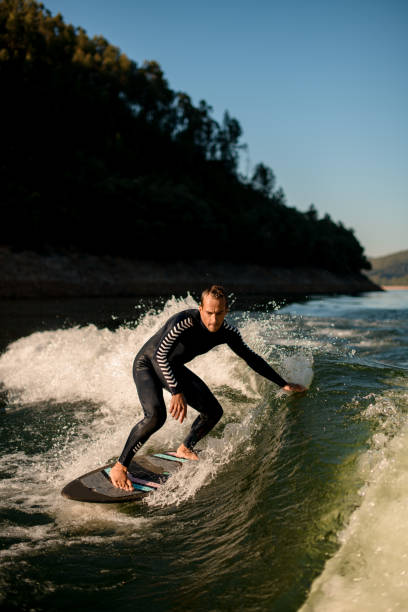 istock active man on wakesurf skilfully riding down the splashing wave 1403512037