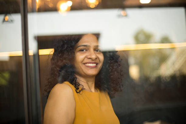 istock Happy woman looking out through glass window 1403514002