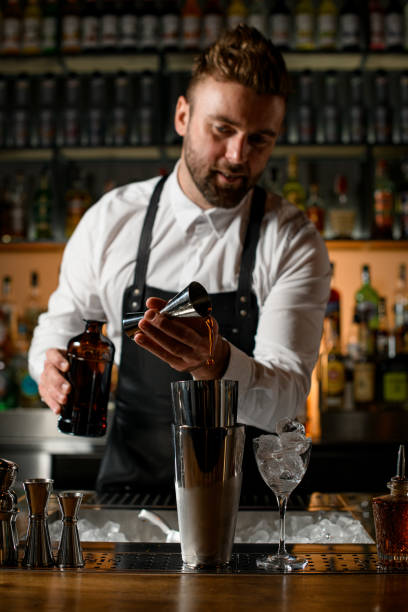 istock view of shaker cups on bar counters in which the bartender carefully pours a drink 1403514575