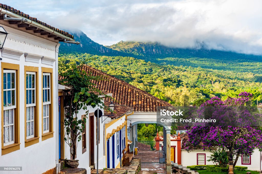 Historic colonial houses with the mountain and forest vegetation in Tiradentes city Historic colonial houses with the mountain and forest vegetation lit by the sun in the city of Tiradentes in Minas Gerais, Brazil Tiradentes - Brazil Stock Photo