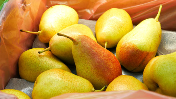 Close-up of many beautiful pears in a trading box stock photo