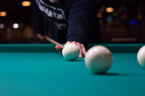 istock Russian billiard player aims to shoot white ball with cue 1403522856