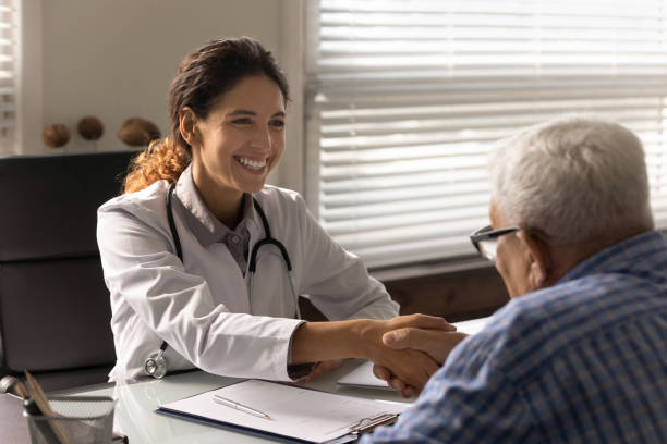 istock Happy physician shaking hands with grateful old man on meeting 1403523105