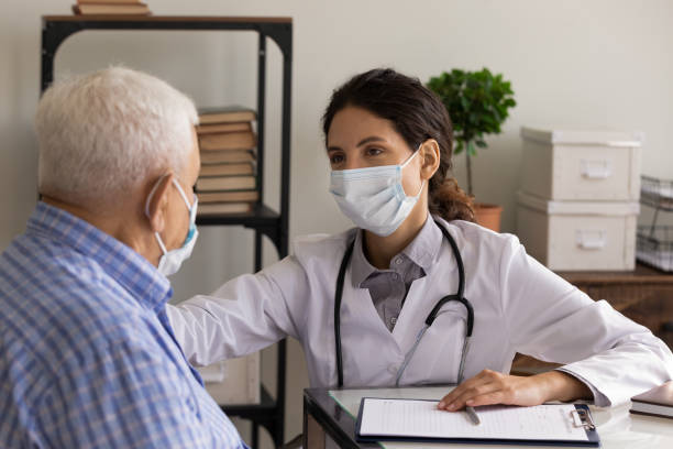 istock GP doctor in face mask giving support and consultation 1403523139