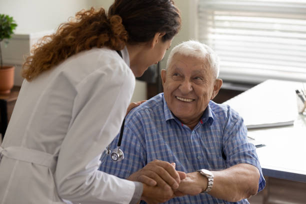 Friendly doctor and optimistic elder 80s man meeting in office