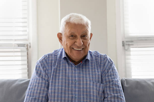 feliz hombre mayor de los 80 mirando a la cámara con una sonrisa dentada - one senior man only grandfather portrait old fotografías e imágenes de stock