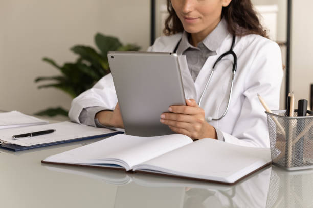 istock Female physician using tablet computer, giving online virtual consultation 1403523166