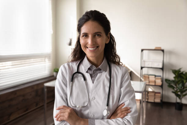 feliz médica gp feminina em casaco branco olhando para a câmera - equipamento em geral - fotografias e filmes do acervo